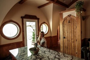 A kitchen with a marble countertop, a wooden door, and a window.