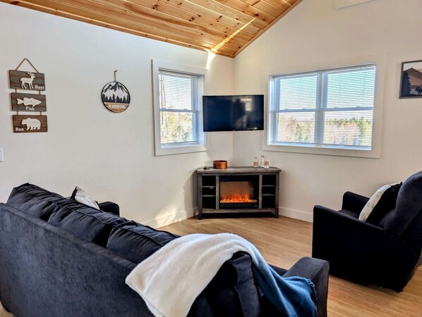A living room with a fireplace, a television, and a couch.