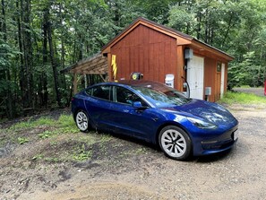 Sininen auto oli pysäköitynä puisen rakennuksen eteen. Rakennuksessa oli ovi, jonka yläpuolella luki ”POSTI”, ja sen vieressä oli salamanisku-merkki.