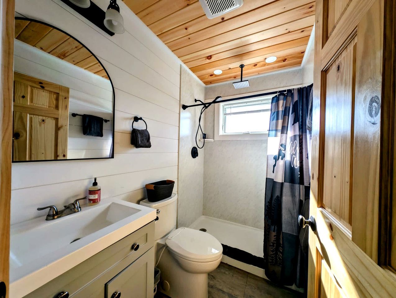 Un baño pequeño con lavamanos, inodoro y cortina de ducha.