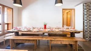 A wooden dining table set with plates, glasses, and cutlery, with benches in front. - Le Grenier - Chalet DDA La Combe (Saint Martin de Belleville)
