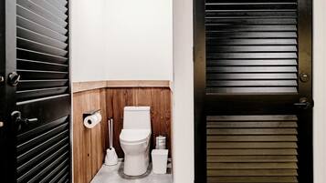 A compact bathroom with a toilet, toilet paper, and a bidet.