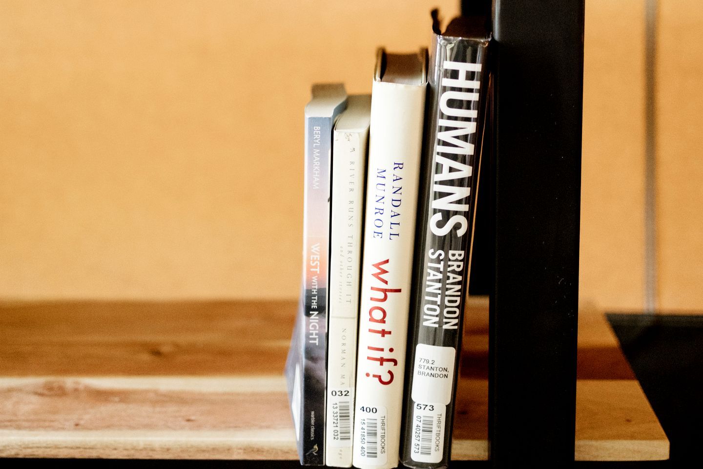 Una estantería con libros, incluyendo títulos como 'What If?' y 'Humans'.