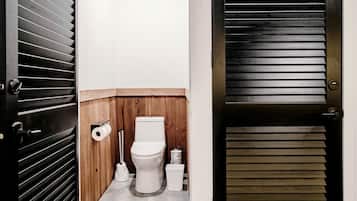 A compact bathroom with a toilet, toilet paper, and a bidet.