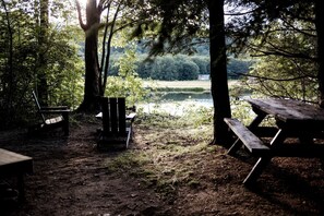 Ein Campingplatz mit Picknicktisch, Bank und Stuhl.