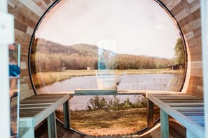 A circular wooden structure with a view of a river and hills.