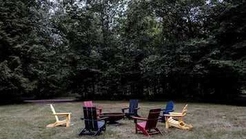 An outdoor seating area with several Adirondack chairs and a small table.