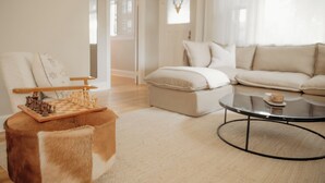 A modern living room with a wooden chessboard, a round coffee table, and a sofa.
