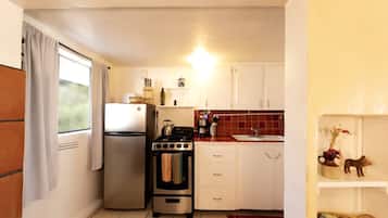 A compact kitchen with a refrigerator, stove, and sink.