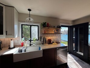A modern kitchen with a large window, a built-in dishwasher, and a view of the outdoors. - Newly renovated 3-bedroom lake home in Gwinn, Michigan - check for availability  (Gwinn)
