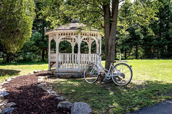 Ein Gartenpavillon mit einem Fahrrad davor.
