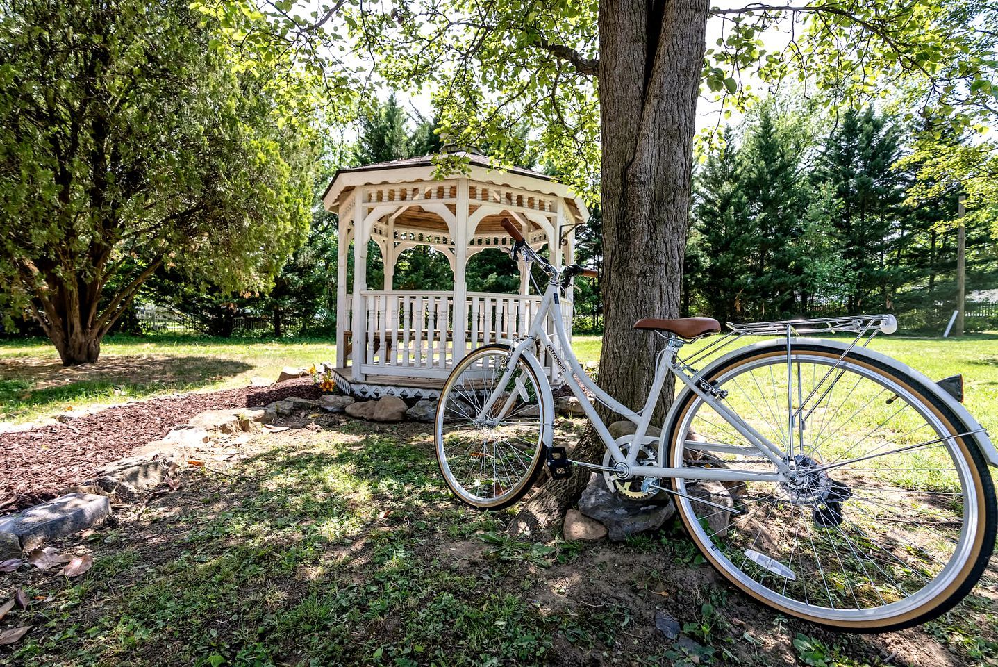 A bicycle parked next to a gazebo in a park.