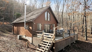 A wooden cabin with a deck, surrounded by trees. - Lustrous Lakefront Cabin Oasis near Lake Ferndale in West Virginia (Springfield)