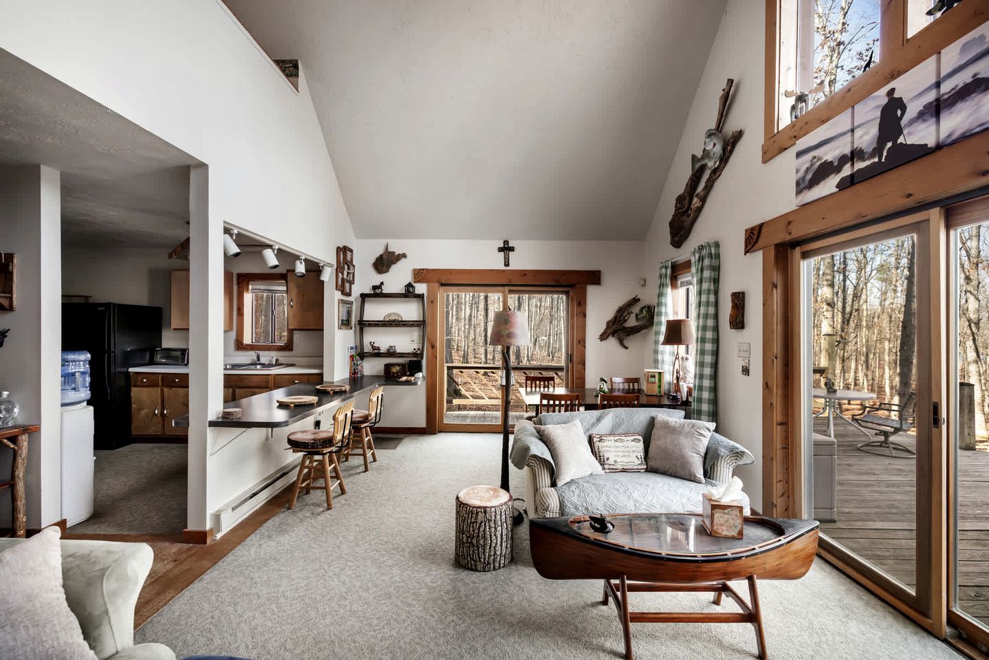 A spacious living room with a large window, a dining area, and a kitchen.
