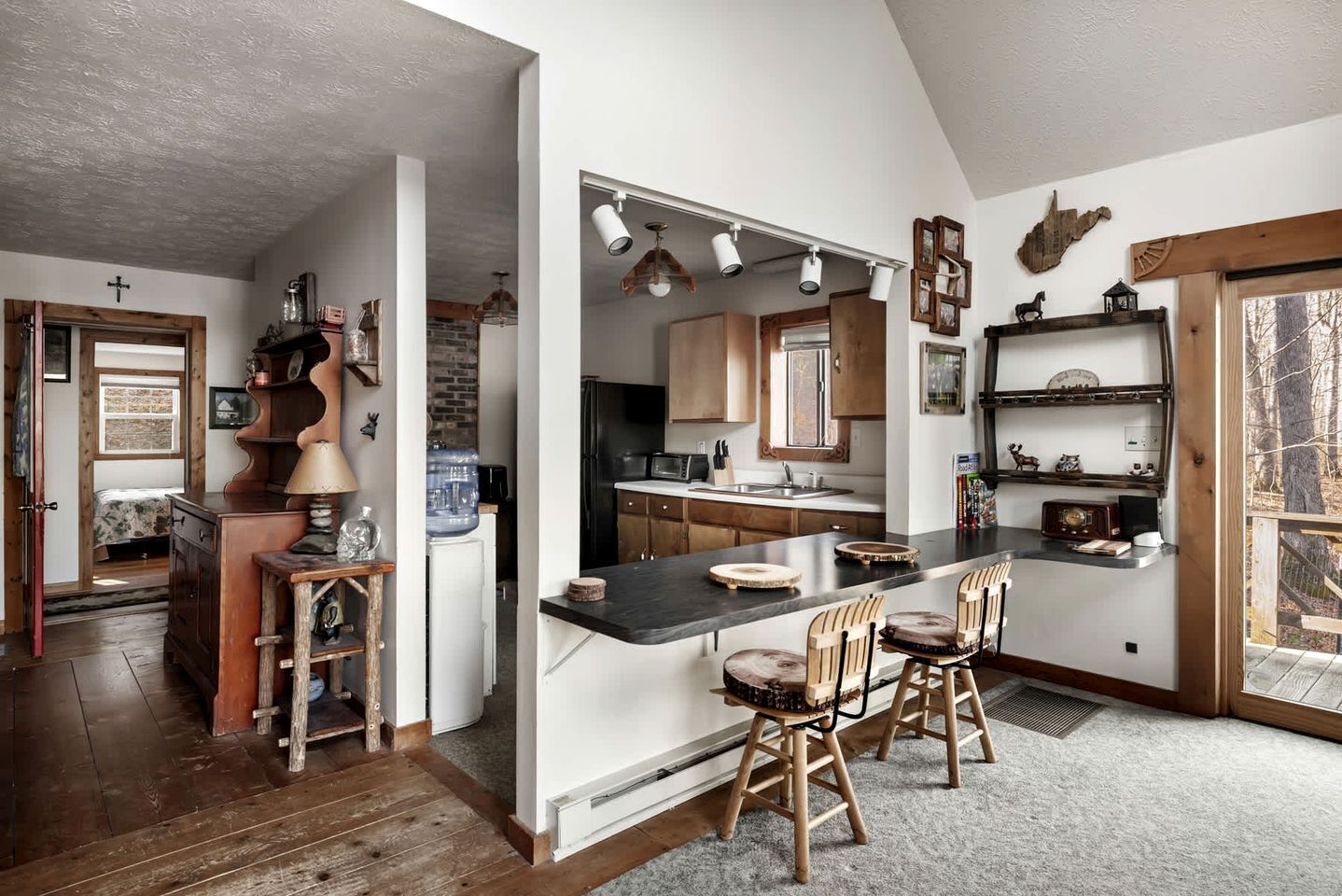 A modern kitchen with a central island, wooden chairs, and a dining area.