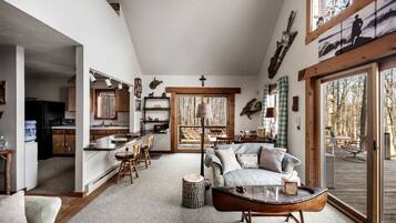 A spacious living room with a large window, a dining area, and a kitchen.