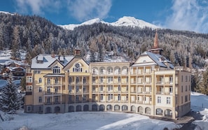 A large, multi-story hotel with a symmetrical facade, arched windows, and a central tower. - Hotel Joseph's House (Davos)