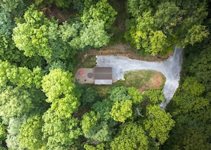 Luchtbeeld van een pand met een huis, een geasfalteerde oprit en een klein terras met tuinmeubilair.
