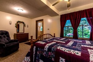 A bedroom with a bed, a chair, a dresser, a mirror, and a window with curtains. - Secluded West Virginia Cabin Rental on the Edge of Monongahela National Forest (Riverton)
