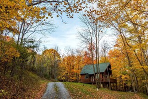 A cabin surrounded by autumn foliage, a gravel path leading to it, and a clear sky. - Secluded West Virginia Cabin Rental on the Edge of Monongahela National Forest (Riverton)