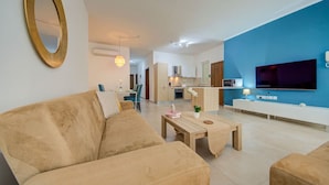 Una sala de estar moderna con sofá, mesa de centro y televisor.