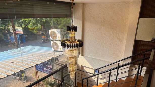 A hotel interior with a staircase, a chandelier, and a view of the outside construction area. - The Mayfair Hotel (Indore)