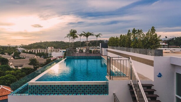 Ein Pool auf dem Dach mit Blick auf umliegende Gebäude und Bäume.