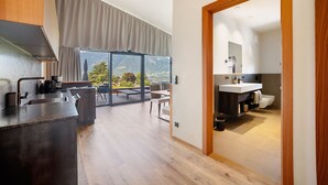 Une cuisine moderne dotée d’une grande fenêtre, un coin repas offrant une vue agréable et une salle de bain avec un lavabo et des toilettes.