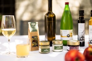 Una mesa con diversos objetos, incluyendo una copa de vino, una botella de vino, una botella verde, frascos y una caja.