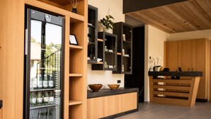 A modern kitchen with wooden cabinetry, a built-in refrigerator, and a counter with bowls. - Apartment 'Oberhaslerhof Floralis' with Mountain View, Wi-Fi and Air Conditioning (Schenna)
