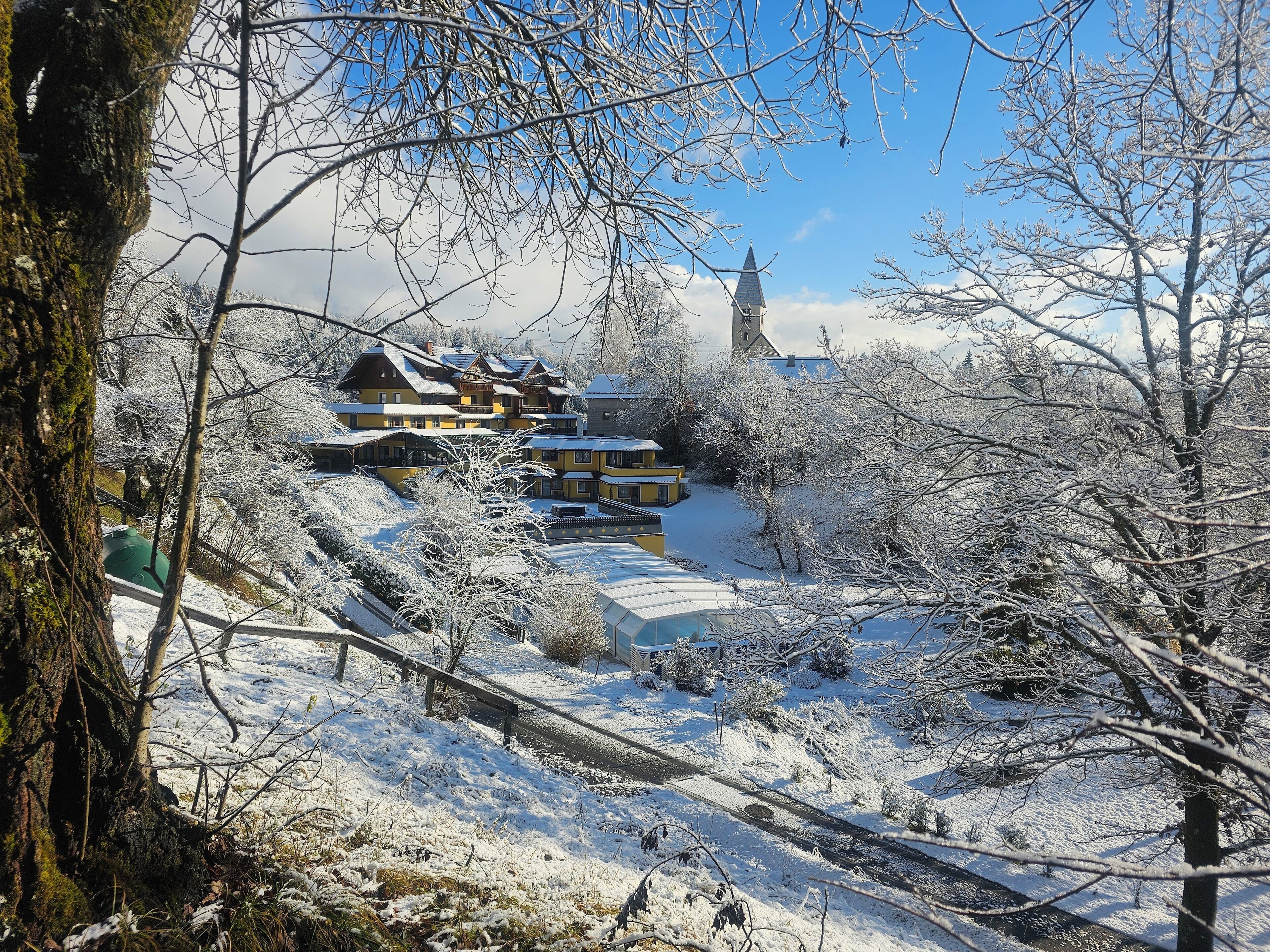 A snow-covered landscape with a large building featuring multiple balconies and a prominent tower.