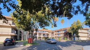 A multi-story residential building with a parking lot. - Rodeway Inn & Suites Rancho Cordova - Folsom (Rancho Cordova)