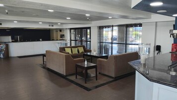 Un interior moderno con un conjunto de sofás, una mesa de centro y una zona de cocina con encimera.