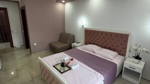 A modern bedroom with a large bed, a bedside table, a nightstand, and a chair. - Cityheart Apartments Ulcinj, Montenegro (Ulcinj Municipality)