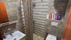 A bathroom with a shower, sink, toilet, and a cabinet above the sink. - Cityheart Apartments Ulcinj, Montenegro (Ulcinj Municipality)