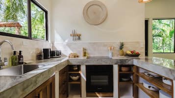 Una cocina moderna con un ventanal grande, horno empotrado y una variedad de utensilios y electrodomésticos.