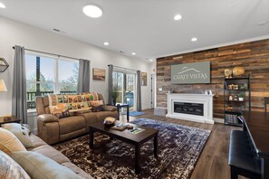 A modern living room with a fireplace, a sofa, a coffee table, and a bookshelf.