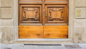 Puerta doble de madera con diseño tradicional, ubicada en un edificio de piedra.