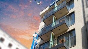 Un hôtel doté de nombreux balcons, un ciel dégagé et un coucher de soleil.