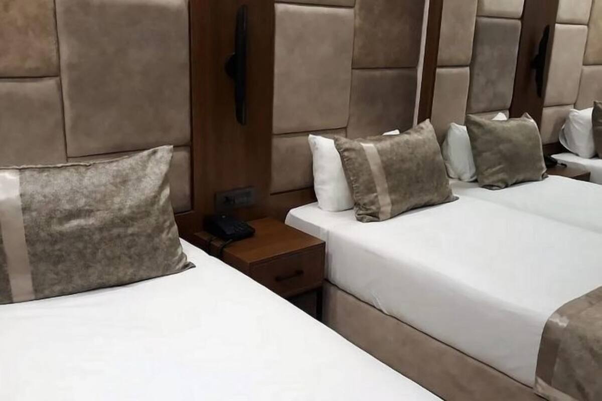 A hotel room with a large bed, a bedside table, and a phone.