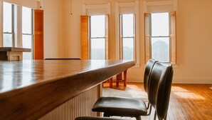 A modern kitchen with a wooden countertop and bar seating. - 15% off Spring Special | Historic Bank | Wi-Fi | Close to Purdue (Oxford)