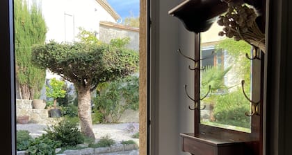 Dans un jardin, charmante petite maison face la montagne aux pieds du village