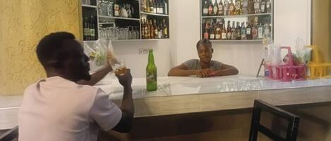 A bar area with shelves of liquor bottles and a counter.