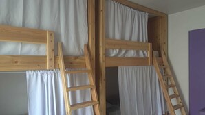A bunk bed with wooden frames and white curtains, a wooden ladder, and a purple wall. - Margarida & Miguel-Turismo e Alojamento (Ponta Delgada)