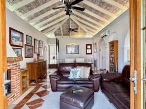 A spacious living room with a high ceiling, a fireplace, a leather sofa, and a dining area. - Puebla Aida with Private Pool by Solrentspain (Mijas Costa)