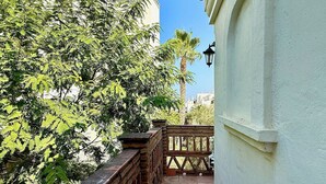 Un balcón con vistas a árboles y un edificio.