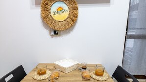 Una mesa de comedor con un posavasos tejido, una bandeja blanca y vasos de jugo de naranja.