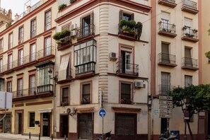 A multi-story building with balconies, air conditioning units, and signs for Hotel America and Hotel Corrubedo.