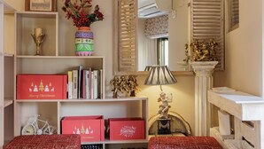 Une pièce avec une bibliothèque, un vase de fleurs, une lampe et une cheminée.