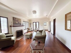 A spacious living room with a fireplace, a sofa set, and a coffee table. - Brand New Vintage La Mesa Storybook Tudor Cottage (La Mesa)